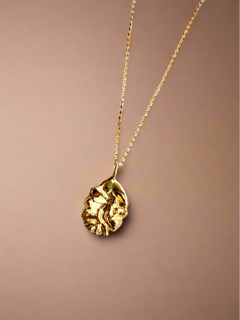 Gold necklace with a pendant on a brown background