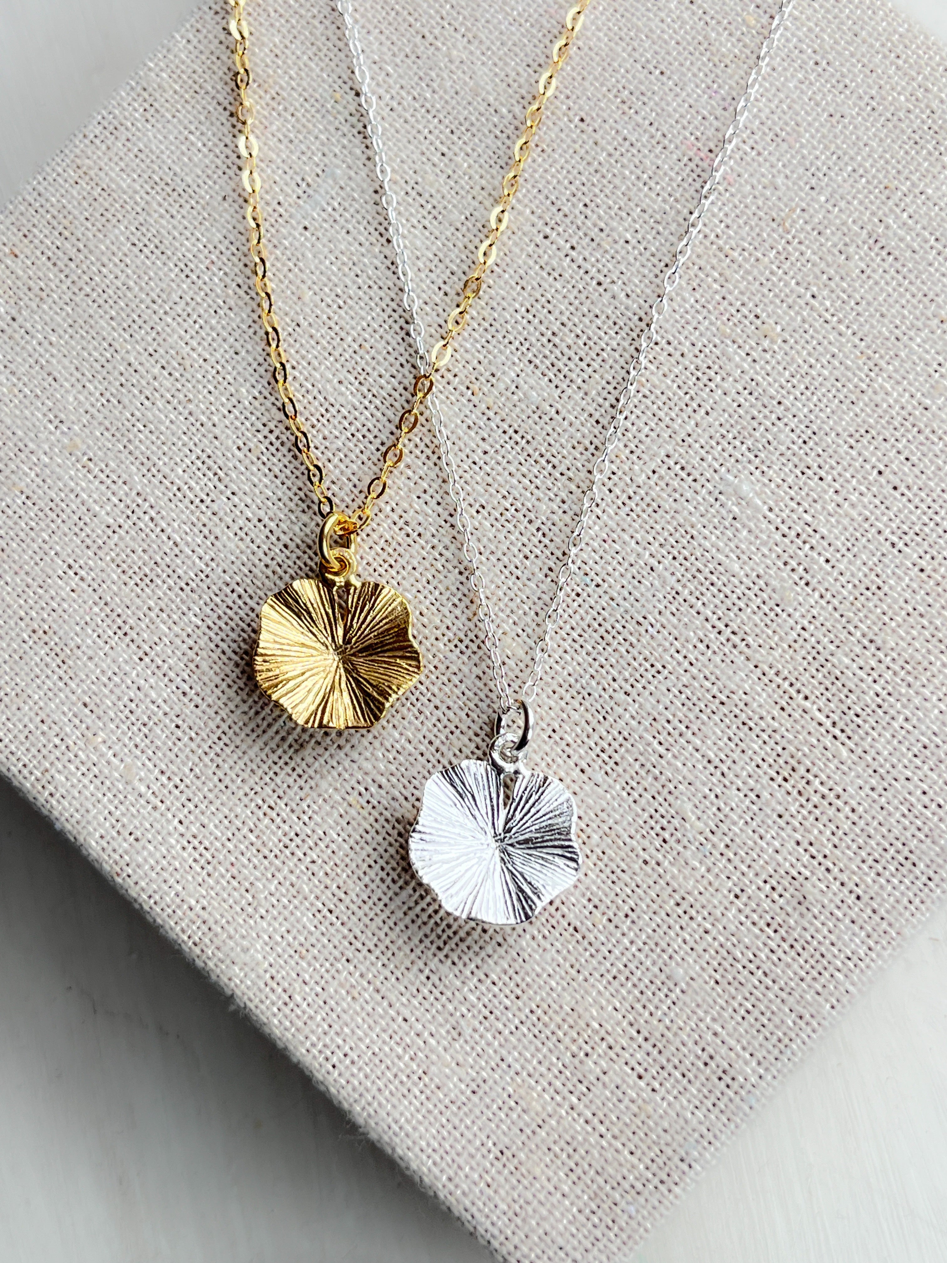 Gold and silver pendant necklaces on a textured surface
