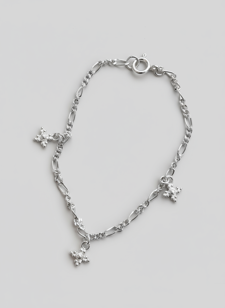 Silver chain bracelet with charms on a beige background